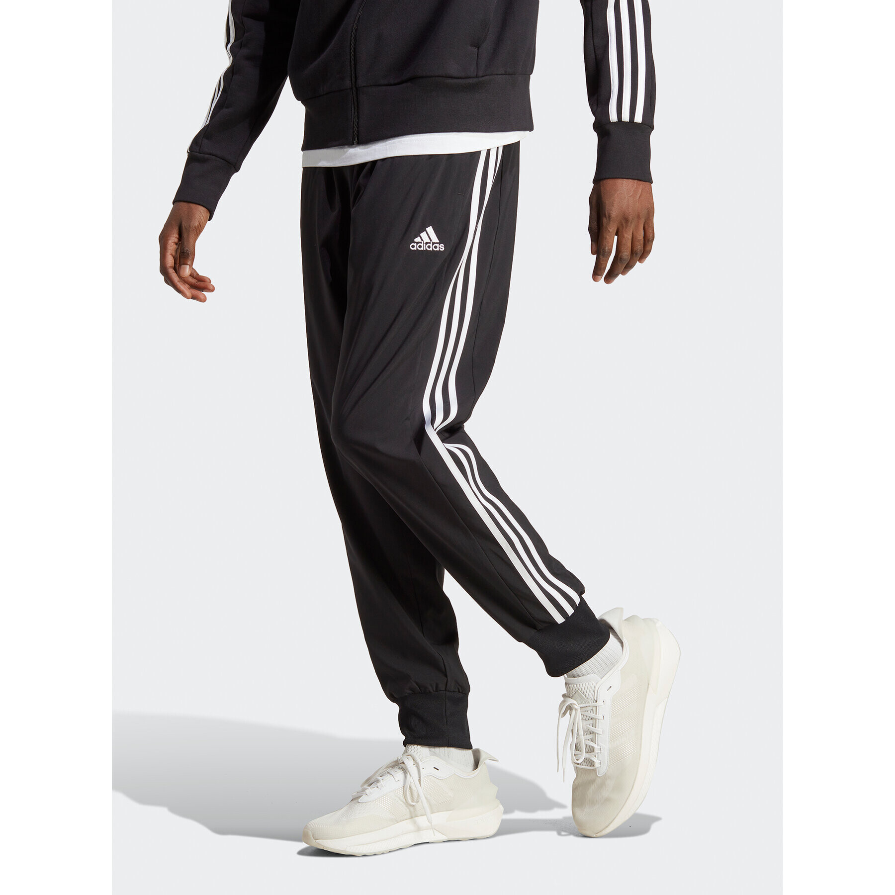 adidas Spodnji del trenirke AEROREADY Essentials Tapered Cuff Woven 3-Stripes Joggers IC0041 Črna Regular Fit - Pepit.si