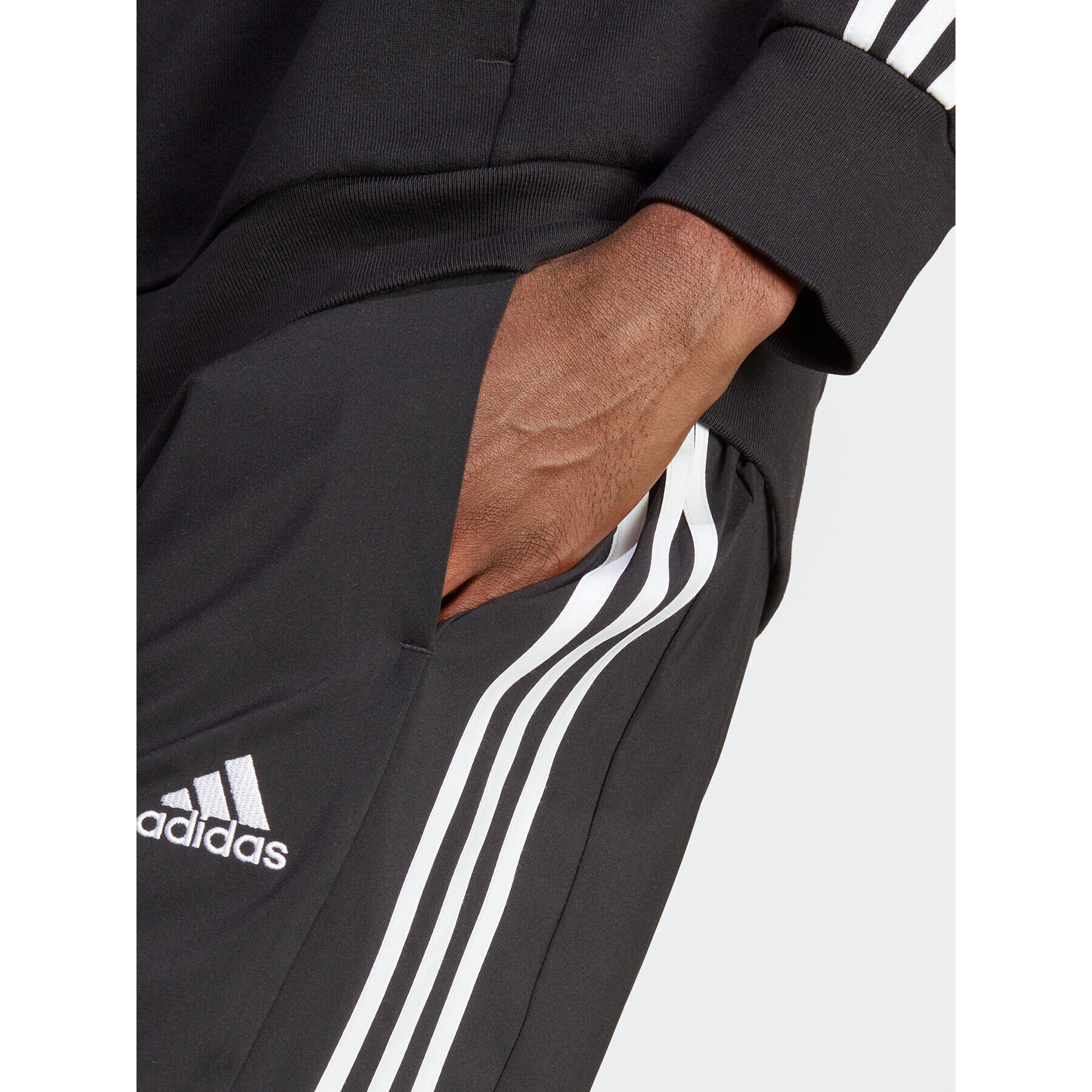 adidas Spodnji del trenirke AEROREADY Essentials Tapered Cuff Woven 3-Stripes Joggers IC0041 Črna Regular Fit - Pepit.si